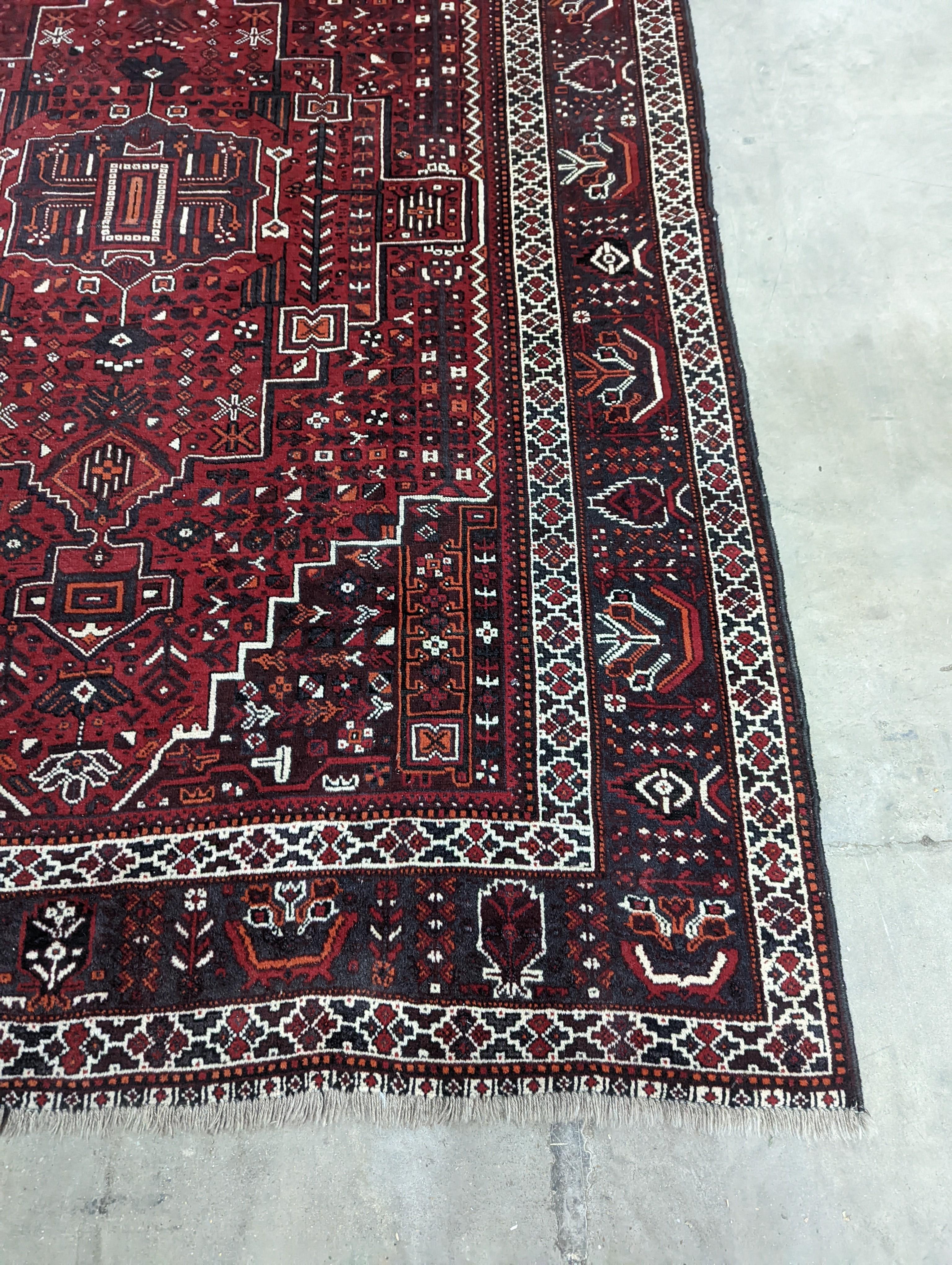 A Caucasian design burgundy ground carpet, 280 x 210cm